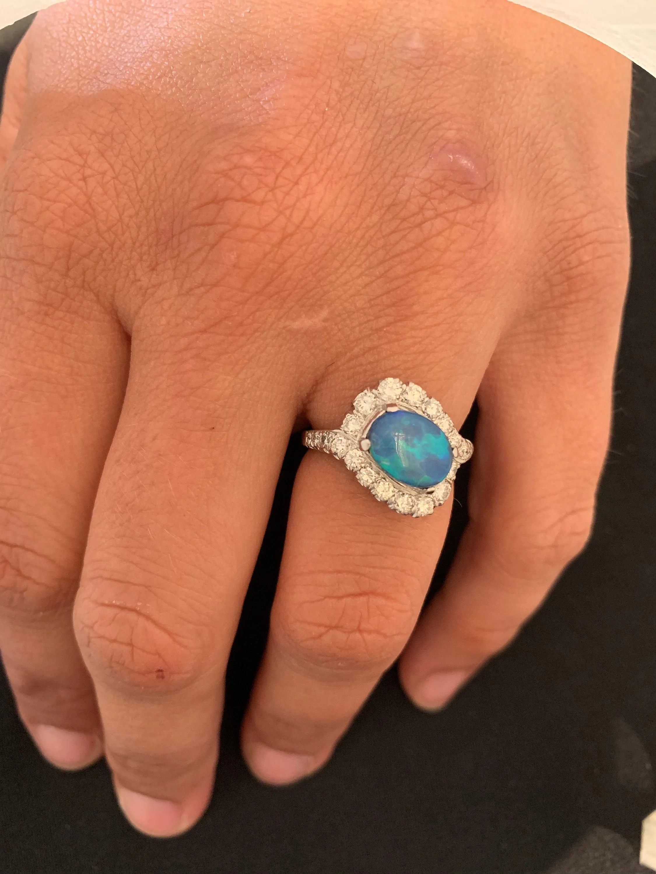 Oval Black Opal Surrounded by a Swirl of Diamonds in White Gold